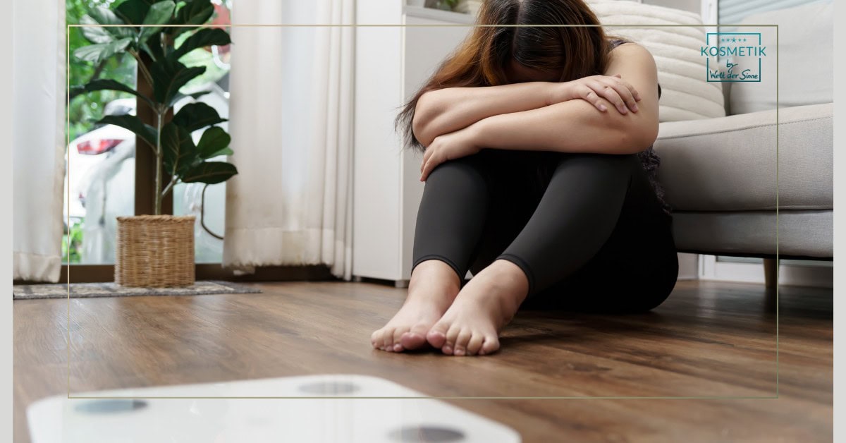 Nachdenkliche Frau sitzt niedergeschlagen auf dem Boden und ist mit ihrem Gesicht und Körper unzufrieden – Abnehmen Leverkusen als Ausweg aus dem Frus
